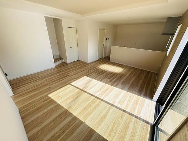 大きな窓から自然光がたっぷり差し込む明るいリビングです。ナチュラルな木目調のフローリングが魅力的な空間となっています。開放感を感じさせる間取りで室内はすっきりとした印象です。