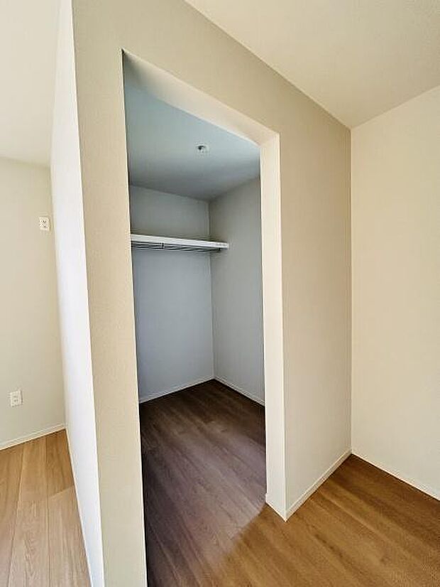 広々とした収納スペースが確保されています。シンプルなデザインで室内がすっきりと整います。扉がなく出入りがしやすい設計です。クローゼット内にハンガーパイプが設置されています。