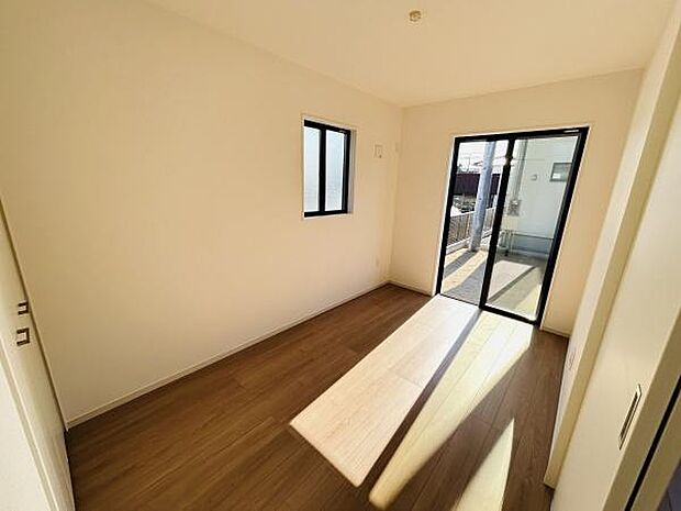 シンプルな内装が特徴の洋室です。明るい光が差し込む二面採光の空間となっています。フローリングの床が落ち着いた雰囲気を演出します。バルコニーへ出られる扉があり使い勝手の良いレイアウトです。