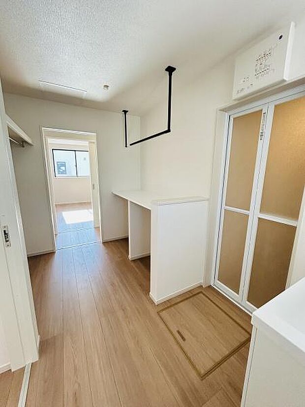 廊下が広めに設計されているので動線が確保しやすい空間です。ナチュラルなフローリングが室内全体に明るさを演出します。室内干しスペースも設置されており生活に便利な工夫が見られます。