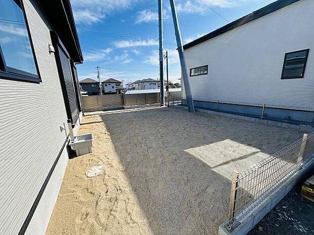 日当たりが良好な庭スペースです。フェンスで囲まれており安心感があります。シンプルな砂地なので幅広い用途にご利用いただけます。周囲に視界を遮るものが少なく開放感のある造りです。