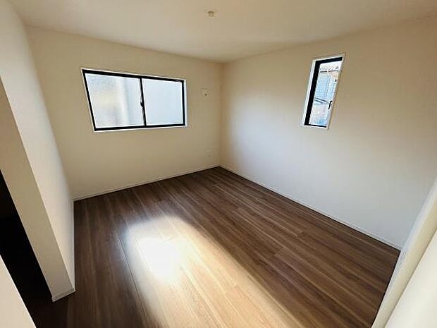 窓から柔らかな光が差し込む明るい寝室です。ナチュラルなフローリングが落ち着いた印象を与えます。シンプルな空間でレイアウトの自由度も高いお部屋です。換気しやすい二面採光も特徴です。