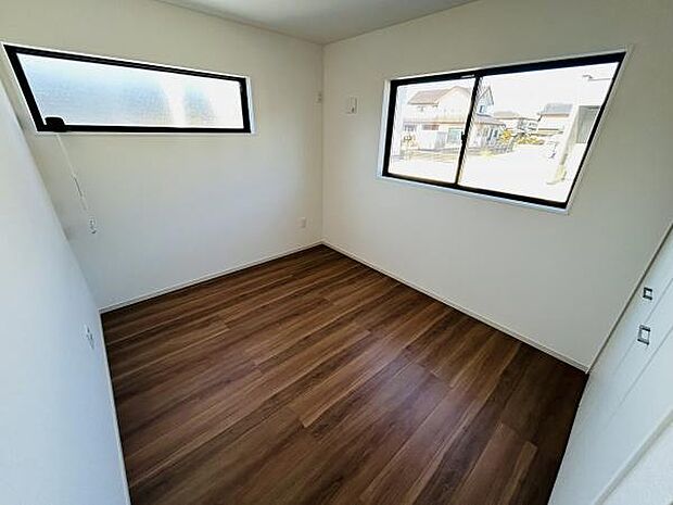 大きな窓があり日中は自然光がしっかりと入ります。シンプルで落ち着いた内装が特徴です。フローリングの色合いが空間に温かみを与えています。無駄のない設計で使いやすい洋室です。