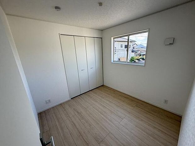 明るい光が差し込む洋室です。シンプルな内装で様々なインテリアに馴染みます。クローゼット付きで収納スペースも十分確保されています。ゆとりある空間が魅力です。窓から外の景色も楽しめます。