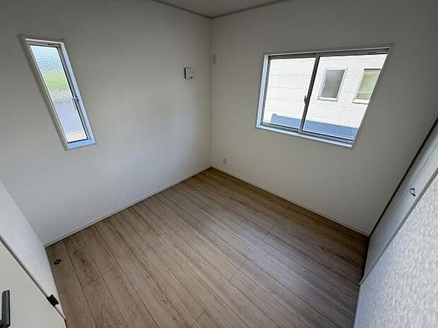 二面採光の洋室は室内にしっかりと明るさを取り込みます。シンプルな内装で使いやすい空間となっています。フローリングの床が落ち着いた雰囲気を演出します。収納スペースもしっかり確保されています。