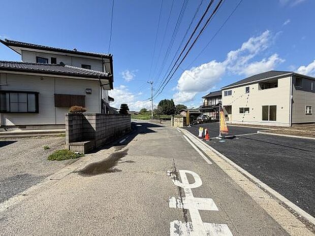 現地写真では住宅街の落ち着いた雰囲気が感じられます。道路幅にゆとりがあり車の出入りもスムーズに行えます。周囲の建物が新しく整った街並みが特徴的です。電柱や配線も整備されているため景観が整っています。
