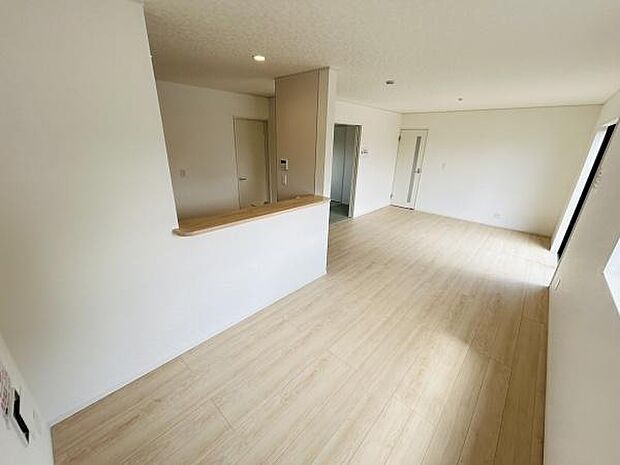 リビングは明るい色調のフローリングが特徴で開放的な空間が広がります。窓からの採光により室内が明るく感じられます。壁と天井のシンプルな色使いがすっきりした印象を与えます。