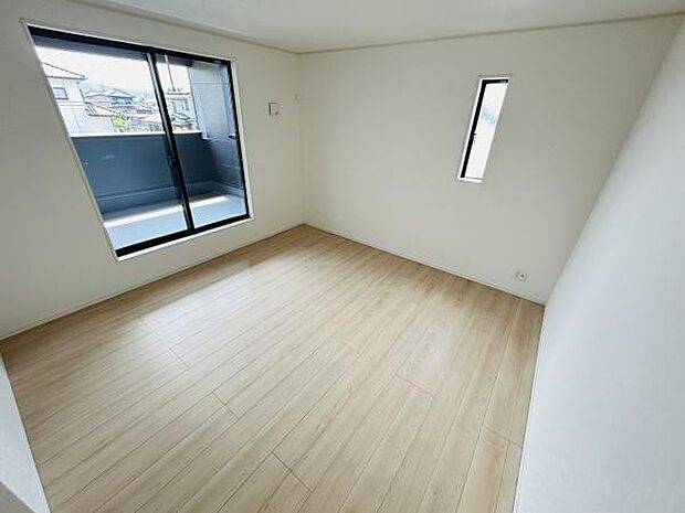 明るい光が差し込むシンプルで使いやすい寝室です。大きな窓から外の景色を楽しめます。落ち着いた色合いのフローリングが魅力です。収納のアレンジもしやすいレイアウトです。