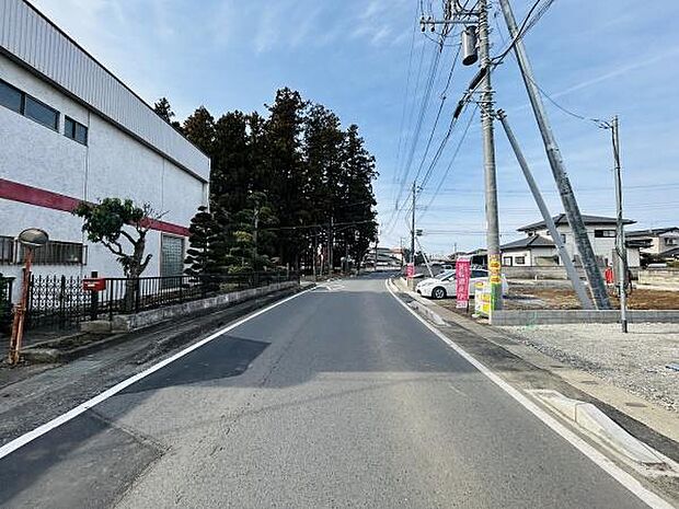 前面道路が広く車の出入りがしやすい環境です。周囲には建物や緑が点在しており開放感があります。電柱や標識も整然と配置されています。舗装もしっかりされていて安心です。