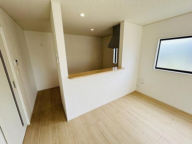 カウンター付きのキッチンは空間をすっきりと見せるデザインです。窓から自然光が入り明るい雰囲気です。床材は木目調で落ち着いた印象です。使い勝手に配慮された換気扇も設置されています。