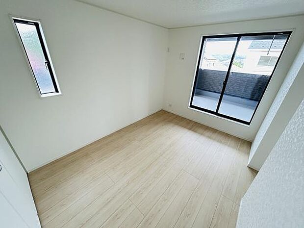 大きな窓があり寝室に明るさをもたらしています。シンプルな内装で使いやすい空間です。ベランダへ出られるスライドドアも便利なポイントです。床はナチュラルカラーで落ち着いた印象です。清潔感のある寝室です。