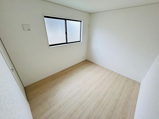 明るい窓が特徴の子供部屋です。シンプルな内装で清潔感があります。床材の色合いが部屋全体を柔らかい雰囲気にしています。十分な広さが確保されています。収納スペースも備えています。