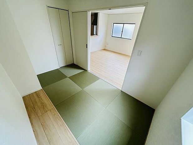 畳の落ち着いた色合いが特徴的な和室です。引き戸でリビングとつながっており使い勝手の幅が広がります。収納スペースも備わっており整理整頓がしやすい設計です。明るい光が差し込む心地よい空間です。