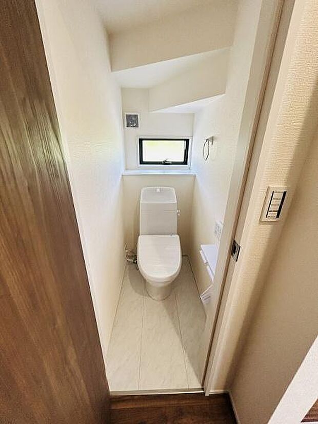 窓が配置されており換気や明るさが確保しやすいトイレです。コンパクトながらも機能的に設計されています。手洗いカウンターやペーパーホルダーも配置されています。清潔感のある内装が特徴です。