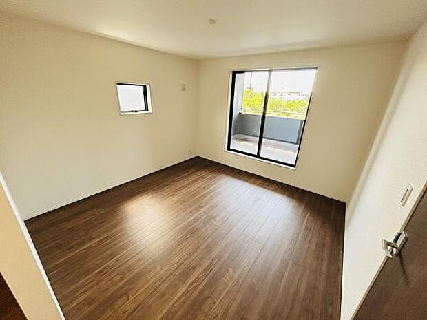 大きな窓から光が差し込み明るさを感じる寝室です。木目調の床が部屋全体を落ち着いた雰囲気にしています。シンプルなデザインで使いやすい空間です。収納やアレンジも楽しめるレイアウトです。