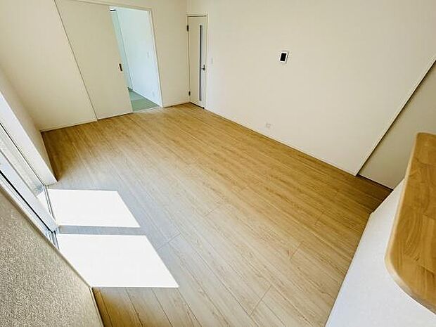 リビングは明るく開放的な空間が広がっています。床は木目調で温かみのある印象を受けます。大きな窓から自然光がたっぷり射し込み室内がより広く感じられます。壁と天井は白を基調とし清潔感があります。