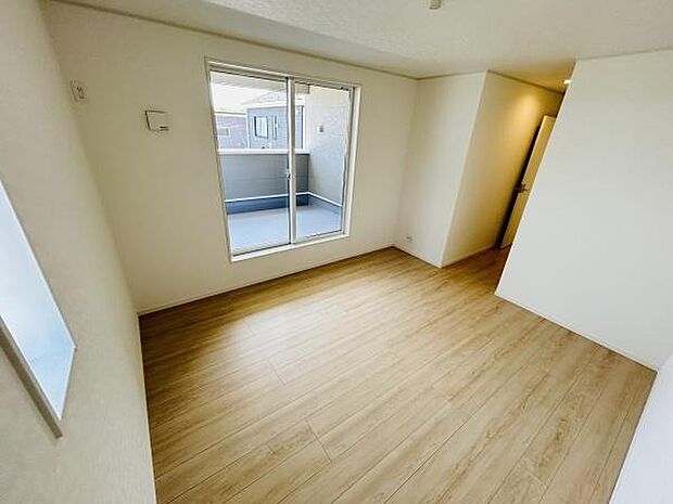 明るい光が差し込む寝室です。バルコニーに面した窓が開放感を演出しています。木目調の床が空間をすっきりとした印象にしています。シンプルな形状でレイアウトの自由度も高い寝室です。