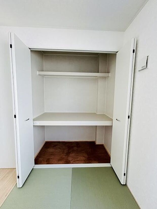 白を基調とした収納スペースは広々とした印象を与えます。棚板も備え付けられており高さのあるものや小物も整理しやすい設計です。開閉しやすい両開き扉もポイントです。