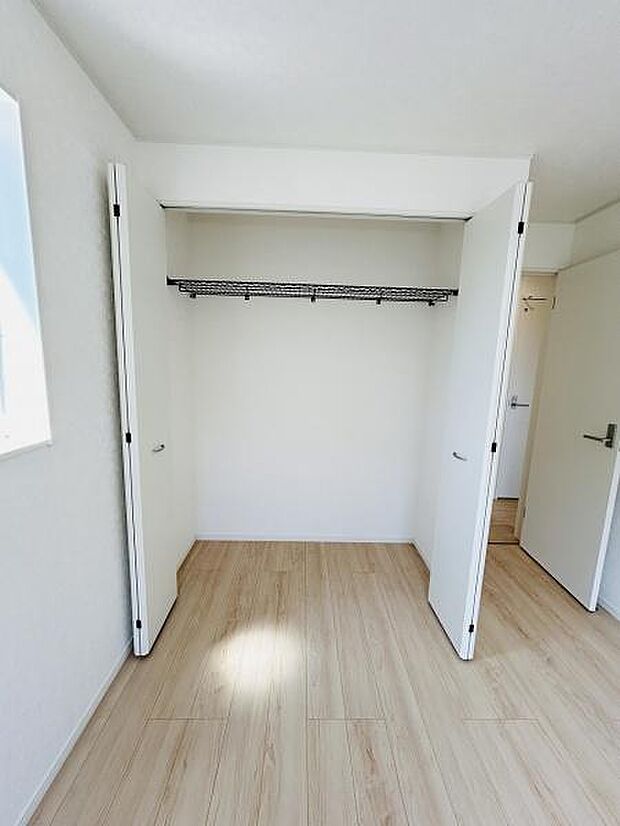 両開きの扉が使いやすい収納スペースです。ハンガーパイプ付きで衣類の整理も簡単に行えます。室内の明るさを活かした清潔な印象の収納です。床までしっかりスペースが確保されています。
