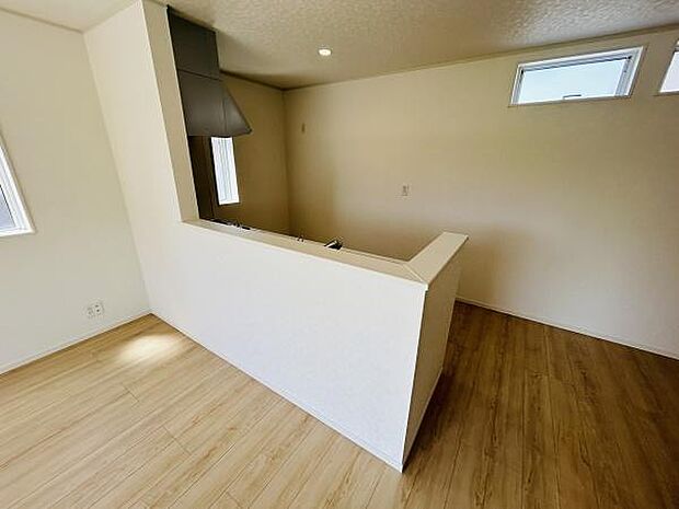キッチンはカウンター付きで部屋全体とのつながりが感じられます。明るい窓付きで採光が確保されています。シンプルで落ち着いた雰囲気の内装です。ナチュラルなフローリングが空間を広く見せています。