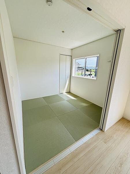 明るい日差しが入る和室です。シンプルな壁と畳が落ち着いた雰囲気を感じさせます。引き戸を使い洋室とのつながりもスムーズです。窓からの景色も楽しめます。使い勝手のよい和室空間です。