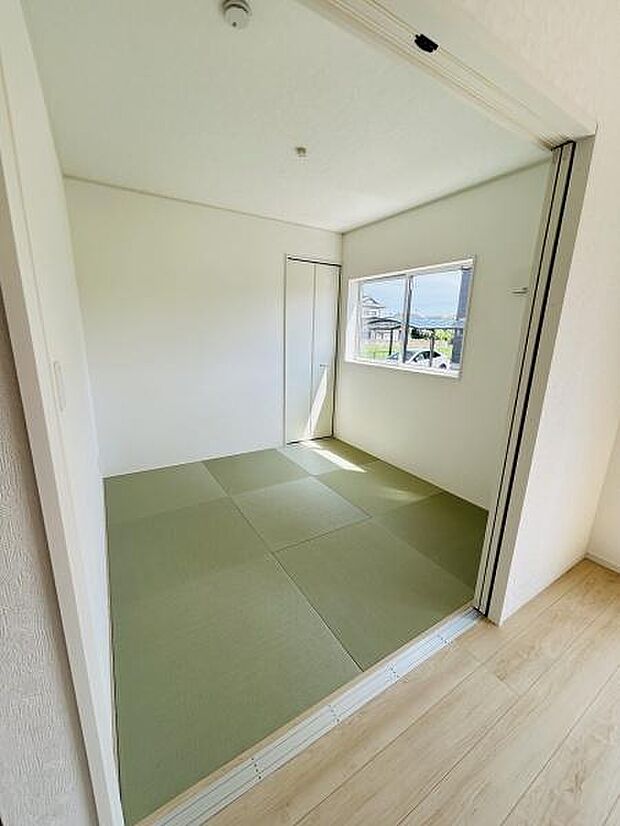 明るい日差しが入る和室です。シンプルな壁と畳が落ち着いた雰囲気を感じさせます。引き戸を使い洋室とのつながりもスムーズです。窓からの景色も楽しめます。使い勝手のよい和室空間です。