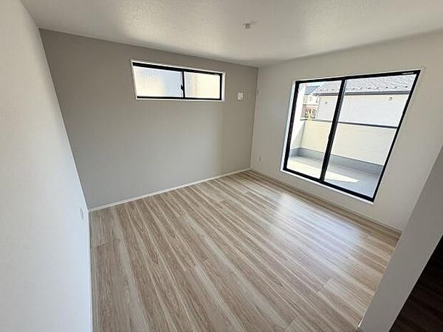 大きな窓から光が差し込む明るい寝室です。シンプルな内装でお好みのインテリアを楽しめます。バルコニーへのアクセスが便利な一室です。落ち着いた雰囲気のフローリングが特徴的です。
