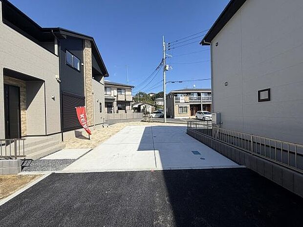 広々とした駐車スペースが用意されています。前面道路との接続もスムーズで車の出し入れが簡単です。敷地全体が明るく開放的な印象を与えます。道路からの視認性も確保されています。