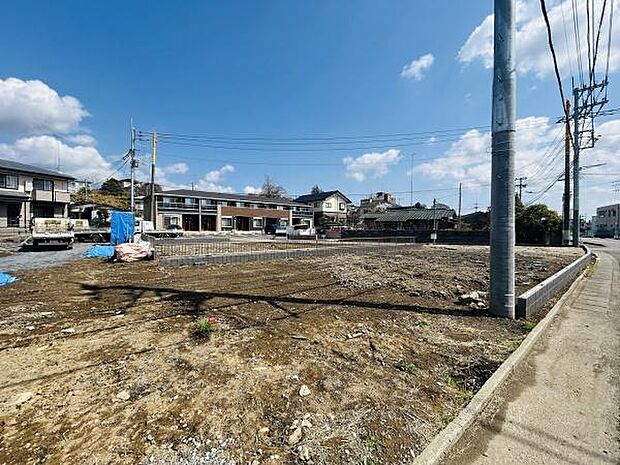 広々とした更地が広がり周辺には住宅が立ち並んでいます。敷地は整った形状で様々な利用が検討できます。前面道路との接道も良好です。住宅や事業用地としてもご相談いただけます。青空が広がる明るい立地です。