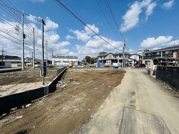 開放感のある空き地が広がり周囲には住宅が立ち並ぶエリアです。道幅も十分に確保されており建築の自由度が高そうな雰囲気です。電柱や配線も整備されていてインフラ面での安心感があります。