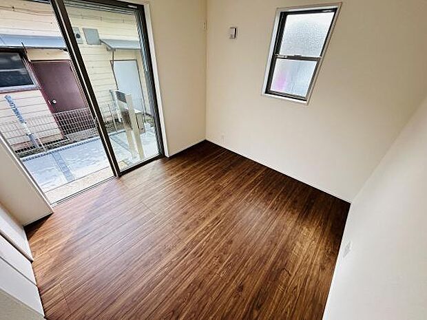 ナチュラルなフローリングがシンプルな雰囲気を演出しています。窓からの明るい光が部屋全体に広がります。洋室ならではのすっきりとした空間です。開放感のあるガラス扉も魅力のひとつです。