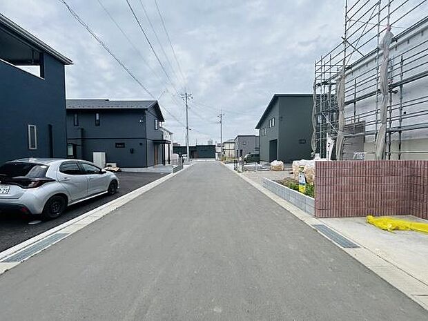 前面道路がしっかり舗装されており車の出し入れもスムーズに行えます。周辺には新築住宅が並び整った街並みです。道路幅にもゆとりがあり見通しの良い現地写真です。清潔感のある環境が感じられます。