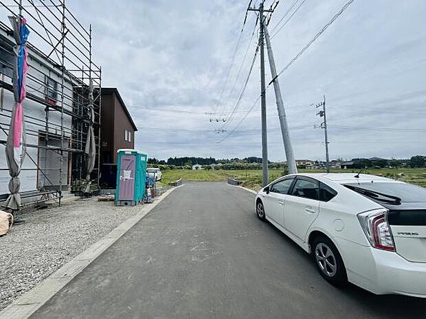 広々とした前面道路が特徴で車の出し入れがしやすい環境です。周囲には自然が広がり開放感を感じられます。新築住宅が建設中で今後の発展にも期待できるエリアです。整備された道路が印象的です。