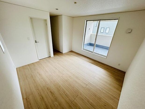 明るい陽射しが差し込む寝室です。床には木目調のフローリングが採用されています。シンプルな内装でお好みのインテリアを楽しむことができます。バルコニーへの出入りもスムーズな造りです。