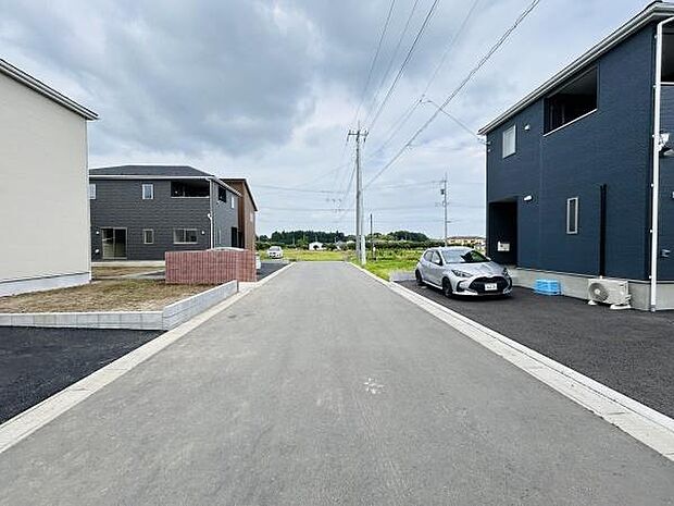 周辺に新しい住宅が建ち並び整然とした街並みが広がっています。前面道路は幅があり車の出入りもスムーズです。舗装された歩道があり住宅街の落ち着いた環境が感じられます。周囲には緑も多く残っています。