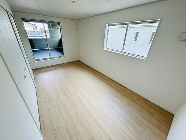 大きな窓から光が入る明るい寝室です。バルコニーへのアクセスもスムーズで開放的な空間が広がります。ホワイトを基調とした壁とやさしい色合いのフローリングが魅力です。ゆったりとした広さが確保されています。