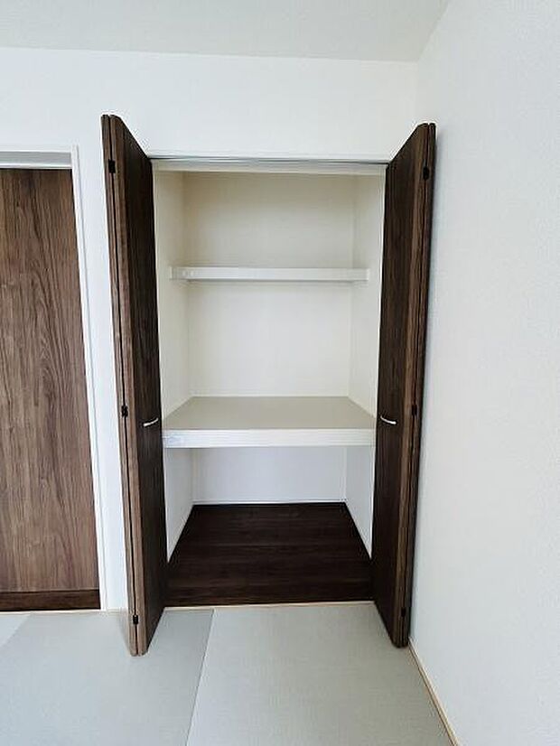 シンプルなデザインの収納スペースです。開き戸で使いやすく内部には棚が設けられています。奥行きも十分でさまざまな用途に活用できます。収納内部は清潔感ある白を基調としています。