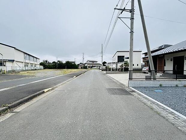 ゆったりとした幅の前面道路が特徴的です。周囲には住宅が立ち並び並木や電線も整然と配置されています。車通りが少なく見通しのよい道路環境が広がっています。