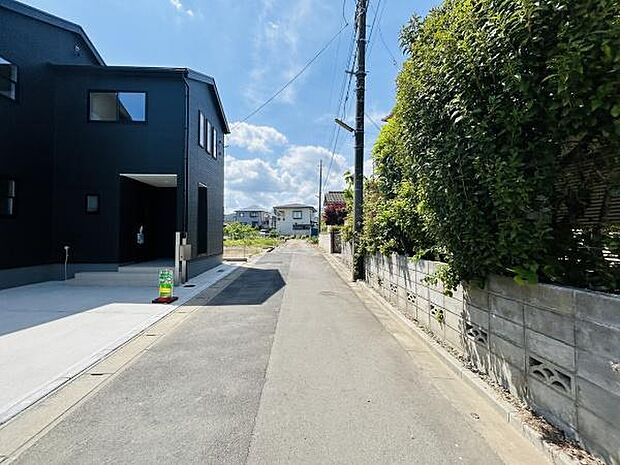 前面道路は舗装されており車の出入りもしやすい環境です。周辺は住宅が並び落ち着いた雰囲気が感じられます。電柱や緑が彩りを添え通行にも便利な道幅です。現地写真で周囲の様子が確認できます。