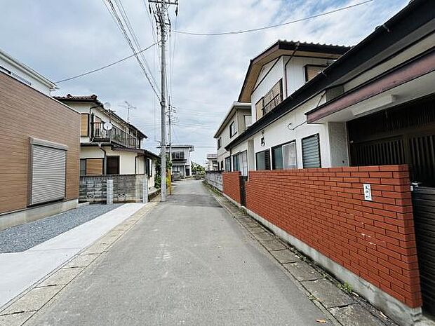 前面道路がまっすぐに伸びており周辺は落ち着いた住宅街の雰囲気です。周囲の家もきれいに整備されています。日当たりや開放感を感じられる現地写真です。車の出入りもスムーズに行えます。