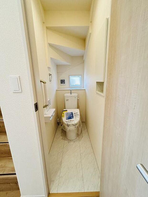 窓が配置されており採光が感じられるトイレです。手洗いスペースも設けられており使い勝手に配慮されています。コンパクトながらもすっきりとした空間です。床材は清潔感のある色合いとなっています。