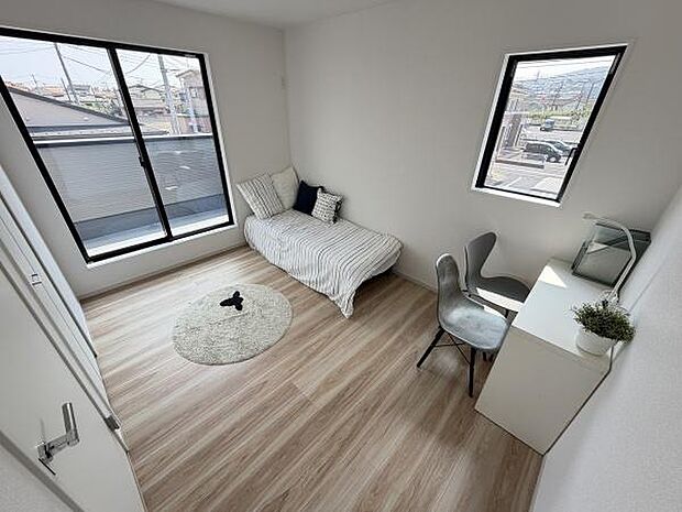大きな窓から明るい光が差し込む子供部屋です。シンプルな内装で家具の配置がしやすいです。デスクとベッドが収まり空間を有効に使えます。ナチュラルな床材が落ち着いた雰囲気を演出します。