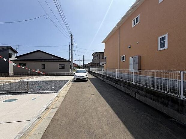 現地の前面道路は幅があり車の通行もスムーズです。周辺は落ち着いた雰囲気となっています。隣家との間隔も確保されており開放感があります。日当たりも良好な印象です。駐車スペースも確認できます。