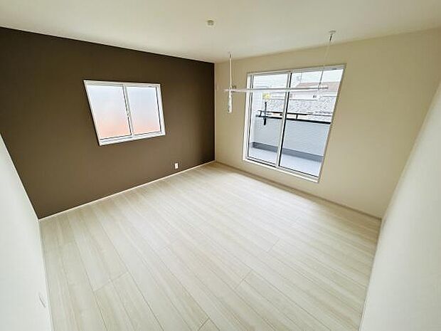 窓からの採光がしっかりと感じられる寝室です。ナチュラルな色合いの床が空間を広く見せます。ダークカラーのアクセントクロスがシンプルな中に落ち着いた雰囲気を与えています。
