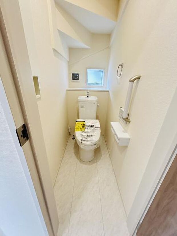 窓付きで明るいトイレ空間です。手すりが設置されており安心してご利用いただけます。シンプルな内装でお手入れもしやすい設計です。限られたスペースを有効活用しています。