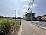 その他：周囲には住宅が並び落ち着いた住宅街の雰囲気が感じられます。前面道路は舗装されていて通行しやすい環境です。電柱や電線がしっかり整備されておりインフラ面も安心です。晴れた空が広がり道沿いに緑が見られます。