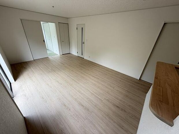 リビングは広々とした空間で使いやすい間取りになっています。ナチュラルな色合いのフローリングが明るい印象を与えます。大きな窓から光が差し込み室内がしっかりと明るくなります。