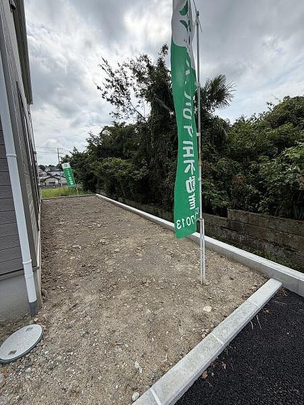 敷地の横に広がる庭スペースが確保されています。明るい空間で奥行きのある形状が特徴です。道路との間に仕切りもあり独立性が感じられます。建物の側面からも庭へのアクセスがしやすい配置です。