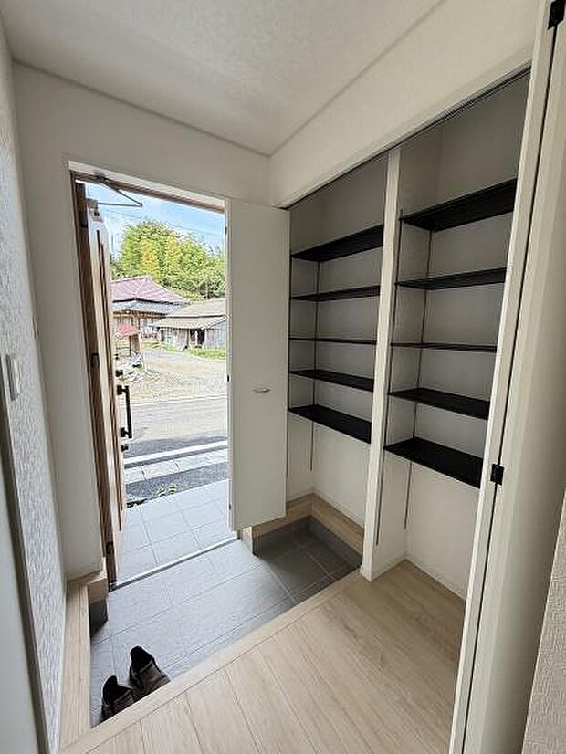 玄関に収納棚が備わっており整理整頓に便利です。明るい光が差し込む空間となっています。室内と玄関の床材が分かれていて使いやすい設計です。屋外へのアクセスもスムーズです。