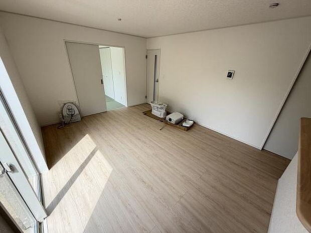 大きな窓から光が入る明るいリビングです。シンプルな内装でどんな家具とも調和しやすい空間です。床はナチュラルな木目調仕上げで落ち着いた雰囲気です。部屋全体がすっきりとした印象となっています。